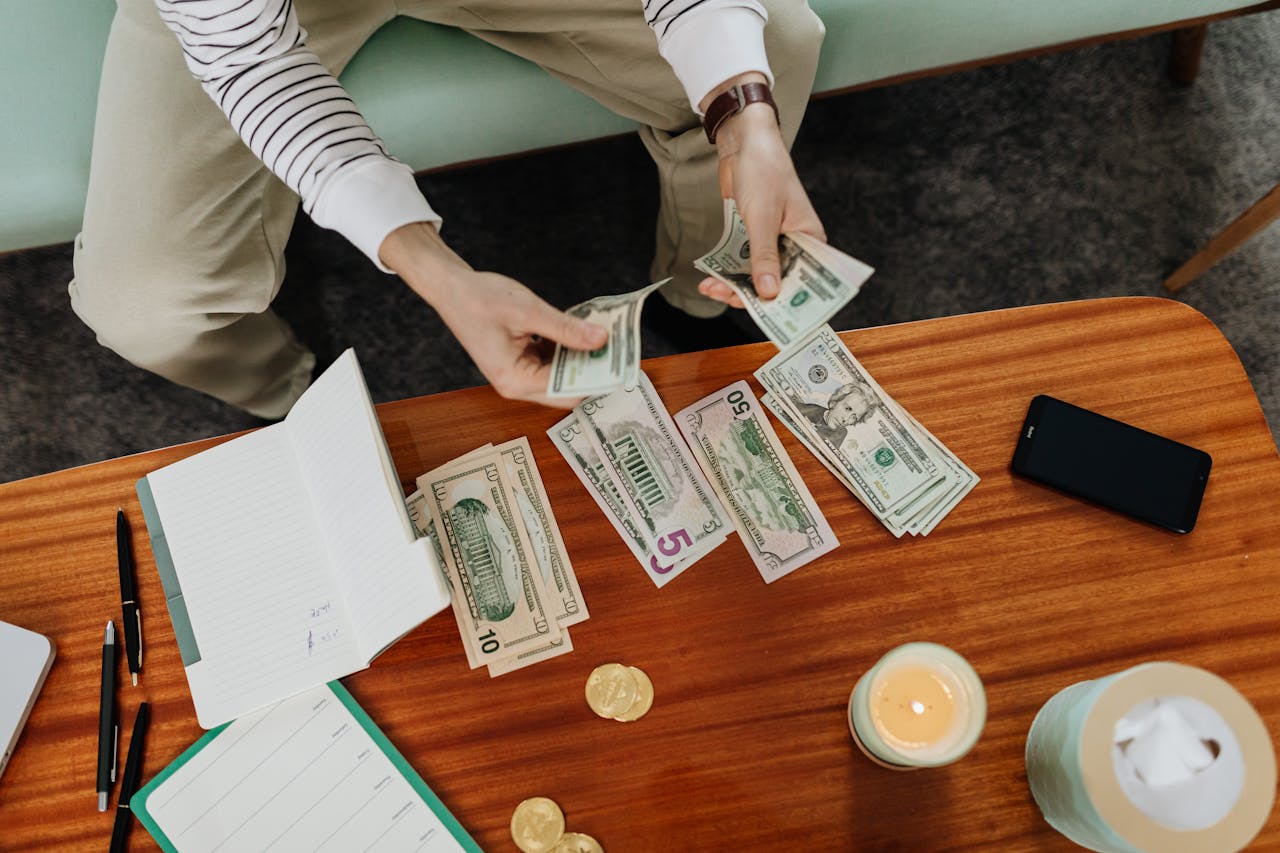 Woman counting money and sorting it into piles.